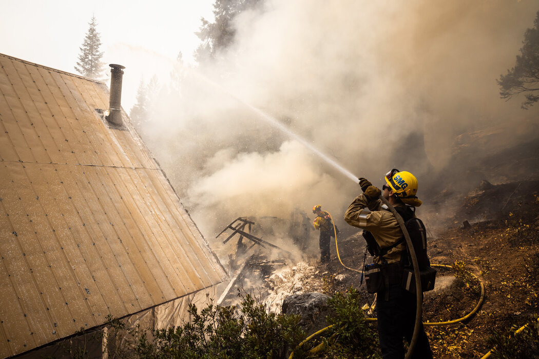 加州斯托伯里市，圣马科斯消防队员在一座燃烧的小屋边。